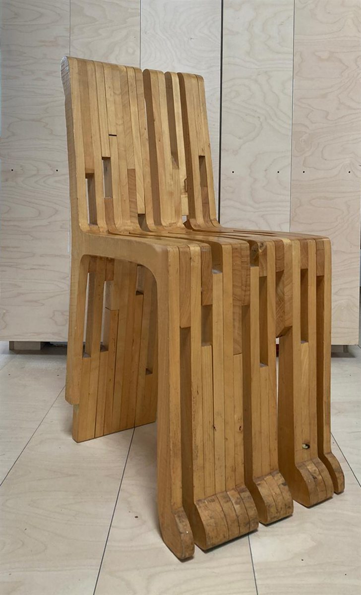 The same chair seen at an angle from the front; the dozens of separate wooden slats are now visible, with openings between them at varying heights.